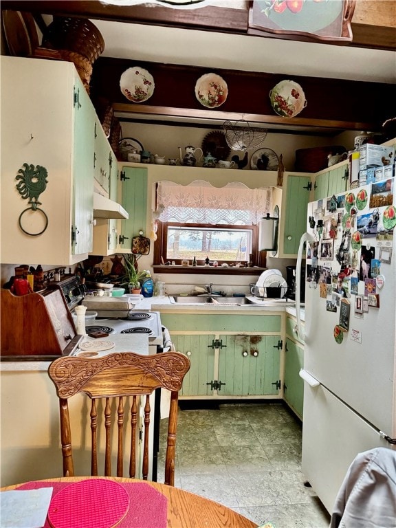 kitchen with white appliances, green cabinets, and sink