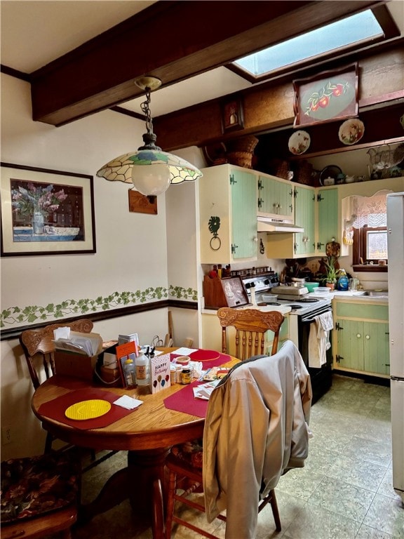 dining space featuring beam ceiling and a skylight