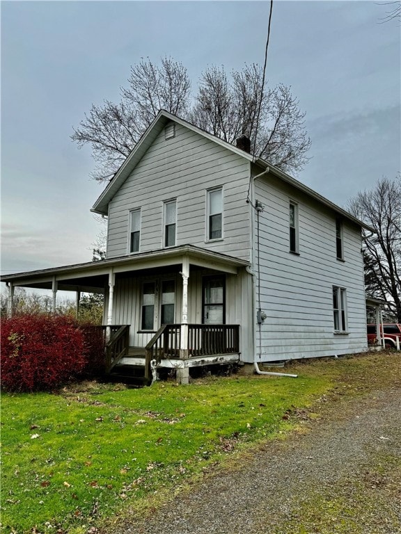 view of front of property featuring covered porch and a front yard