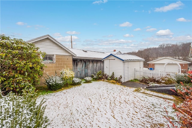 back of house featuring a garage and a storage shed