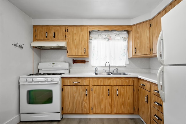 kitchen with sink, white appliances, and light wood-type flooring