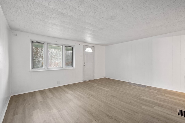 interior space featuring light hardwood / wood-style floors and a textured ceiling