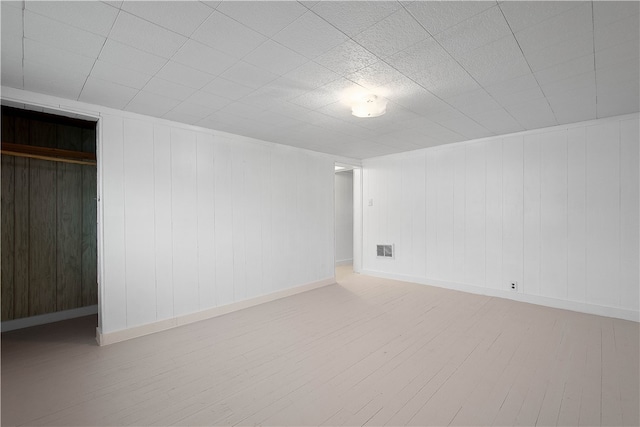 spare room with hardwood / wood-style floors and wooden walls