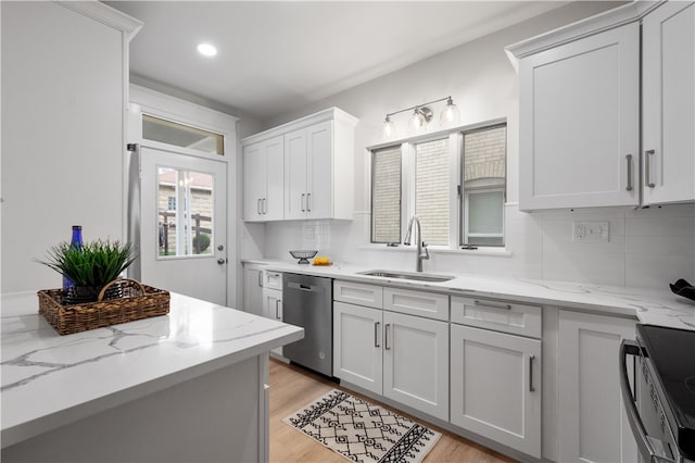 kitchen with white cabinetry, sink, light hardwood / wood-style floors, and appliances with stainless steel finishes