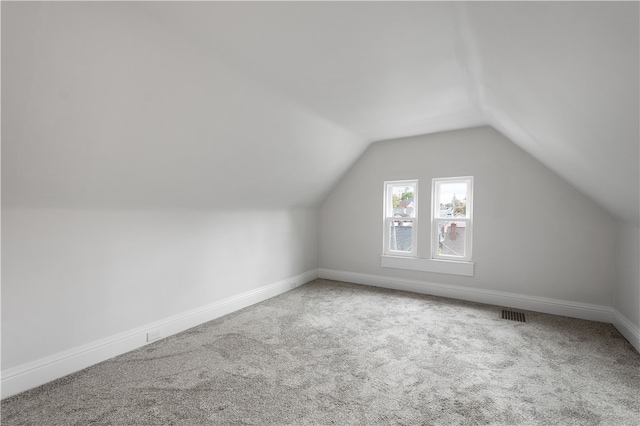 additional living space featuring carpet and vaulted ceiling