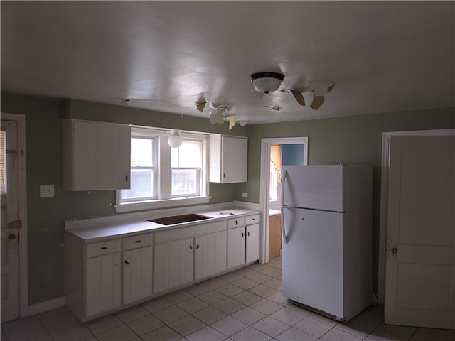 kitchen featuring white cabinetry, white fridge, and light tile patterned floors