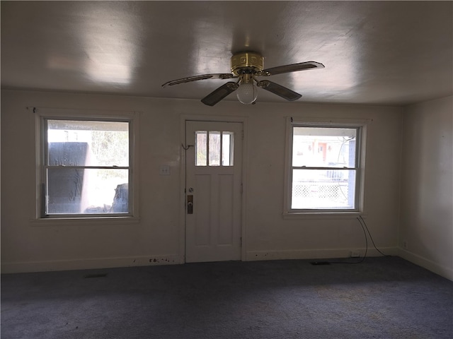 entrance foyer featuring carpet, a wealth of natural light, and ceiling fan