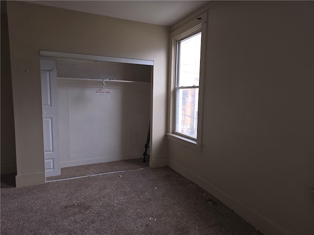 unfurnished bedroom featuring a closet and multiple windows