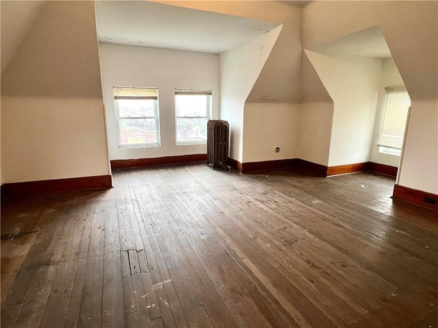 bonus room featuring dark wood-type flooring and radiator heating unit