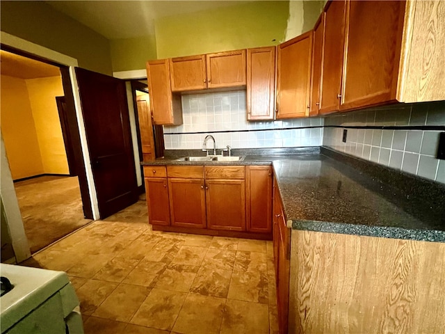 kitchen featuring tasteful backsplash, sink, and dark stone counters