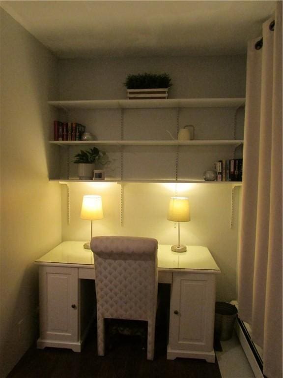 office with built in desk and a baseboard radiator