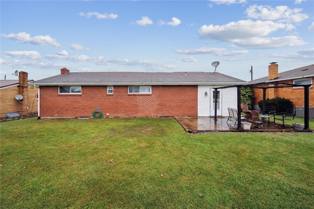 rear view of house featuring a patio area and a yard