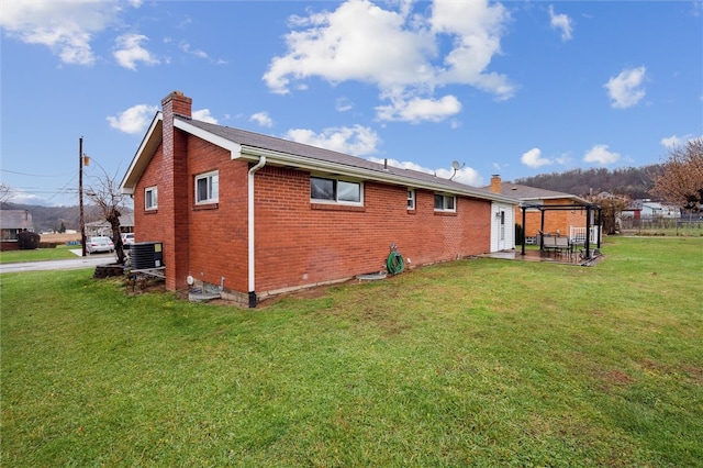 back of house featuring a lawn, cooling unit, and a patio