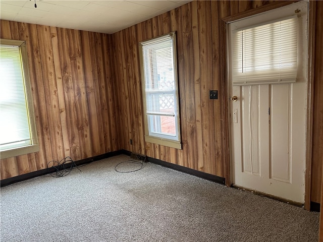 carpeted empty room with wooden walls