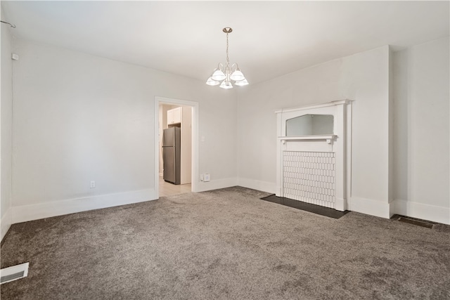 unfurnished bedroom with carpet flooring, stainless steel refrigerator, and a notable chandelier