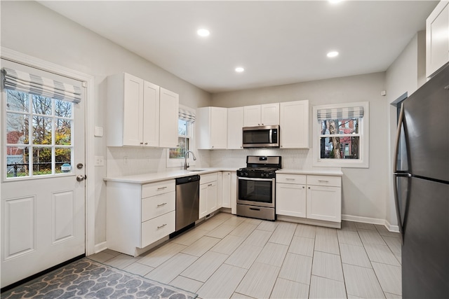 kitchen with white cabinetry, a wealth of natural light, and appliances with stainless steel finishes