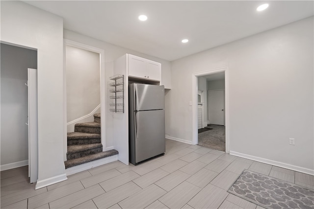 kitchen with white cabinetry and stainless steel refrigerator