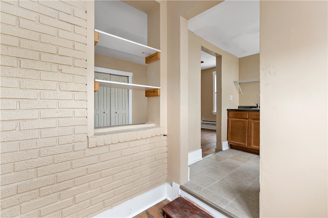 interior space with sink, light wood-type flooring, and baseboard heating