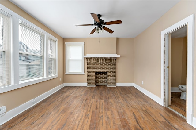 unfurnished living room featuring a fireplace, hardwood / wood-style flooring, and ceiling fan