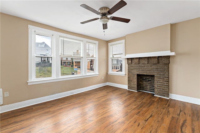 unfurnished living room featuring ceiling fan, dark wood-type flooring, and a brick fireplace