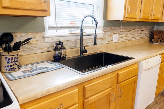 kitchen featuring backsplash, white dishwasher, hardwood / wood-style flooring, and sink