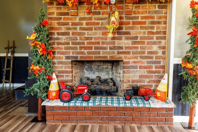 room details featuring wood-type flooring and a brick fireplace