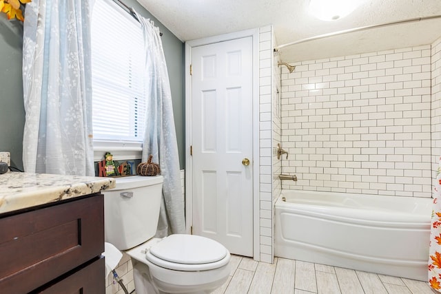 full bathroom featuring shower / bath combo, toilet, a textured ceiling, and vanity