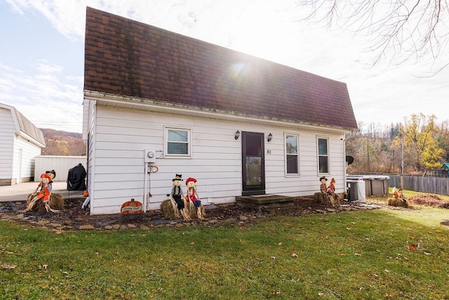 rear view of house featuring a yard