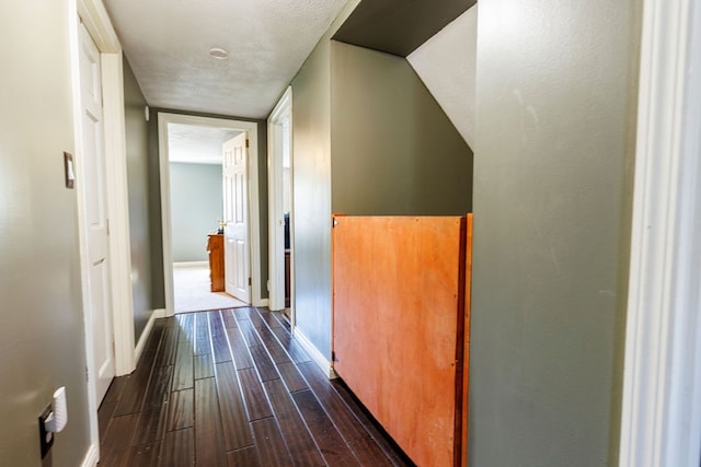 hall featuring a textured ceiling and dark hardwood / wood-style floors