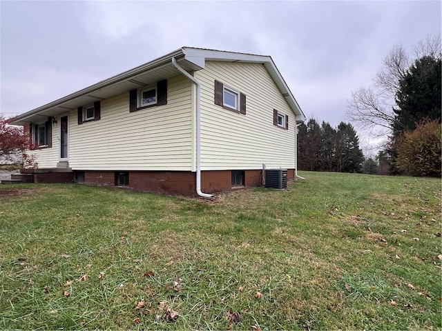 view of side of home featuring a yard and central AC unit