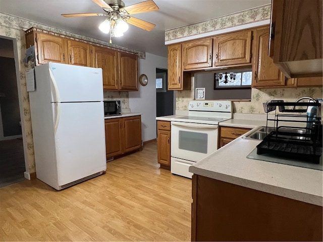 kitchen featuring ceiling fan, white appliances, and light hardwood / wood-style flooring