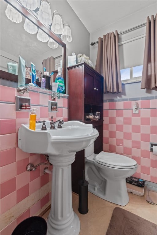 bathroom with tile patterned flooring, tile walls, and toilet