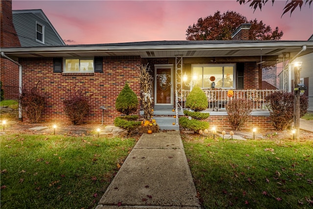 view of front of house featuring covered porch and a yard