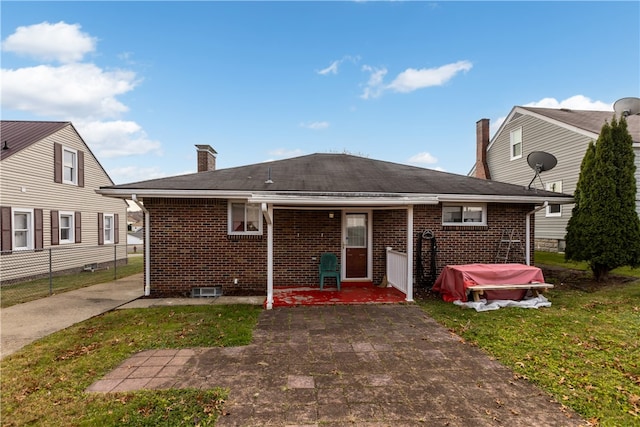 rear view of house featuring a yard