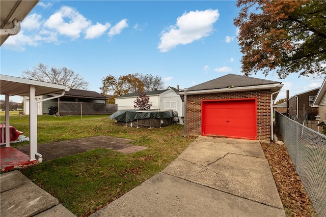 view of yard featuring a garage and an outbuilding