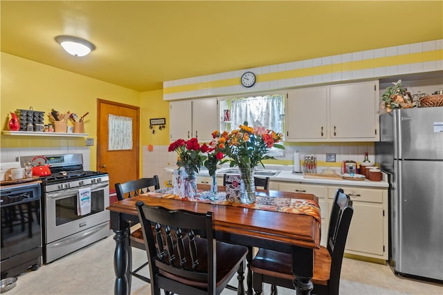 kitchen with backsplash, white cabinetry, and appliances with stainless steel finishes