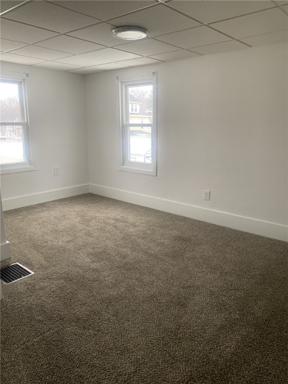 empty room featuring a drop ceiling and carpet flooring