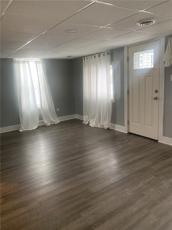 entryway featuring dark wood-type flooring and a drop ceiling