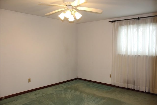 unfurnished room featuring dark colored carpet and ceiling fan