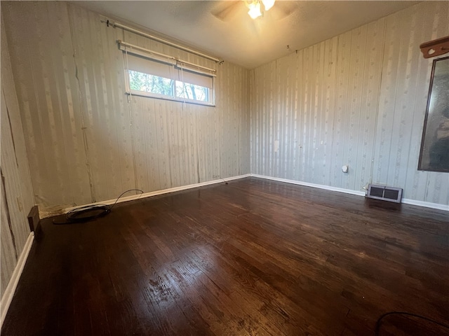 empty room featuring dark hardwood / wood-style flooring and ceiling fan