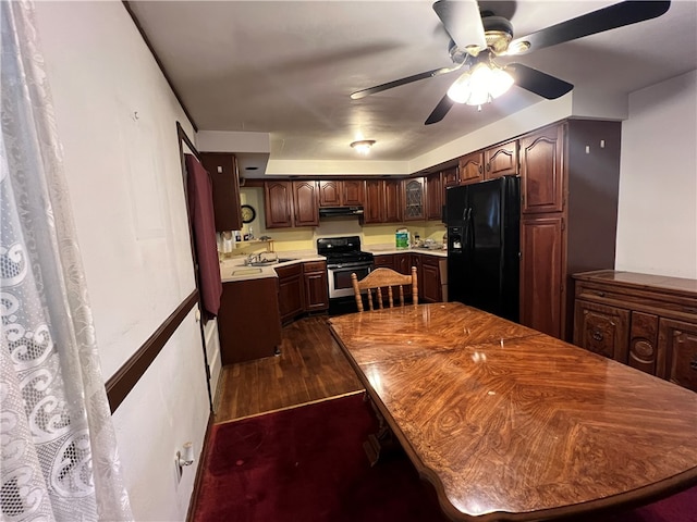 kitchen with stainless steel gas range oven, black refrigerator with ice dispenser, sink, dark hardwood / wood-style floors, and dark brown cabinetry