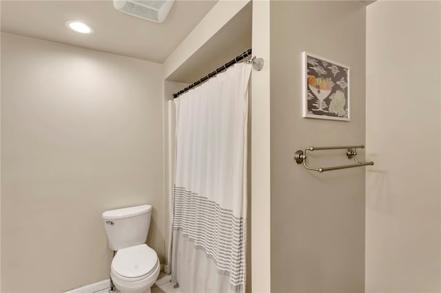 bathroom featuring a shower with shower curtain and toilet