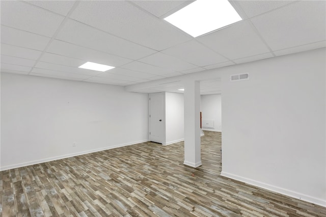 basement with hardwood / wood-style floors and a paneled ceiling