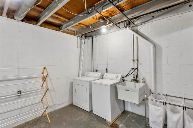 clothes washing area with separate washer and dryer and sink