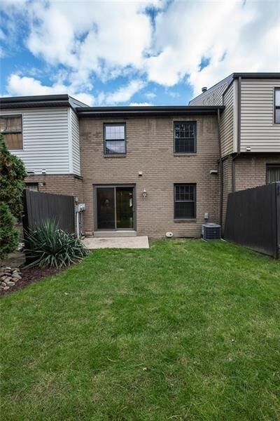 back of property with a lawn and central AC unit