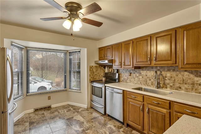 kitchen featuring decorative backsplash, sink, ceiling fan, and stainless steel appliances