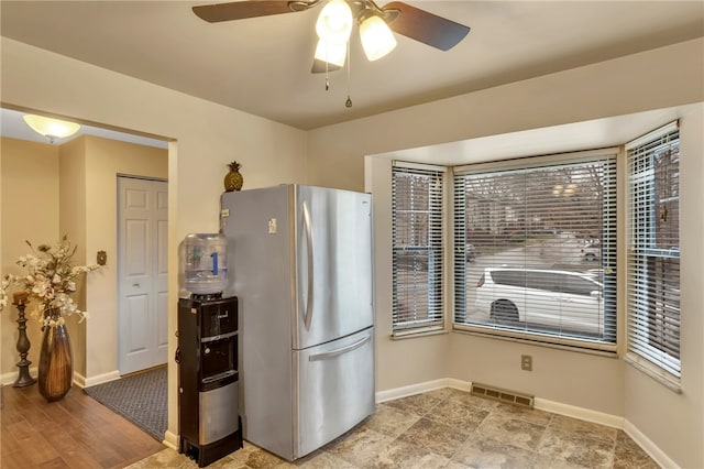 kitchen with ceiling fan, a healthy amount of sunlight, light wood-type flooring, and stainless steel refrigerator