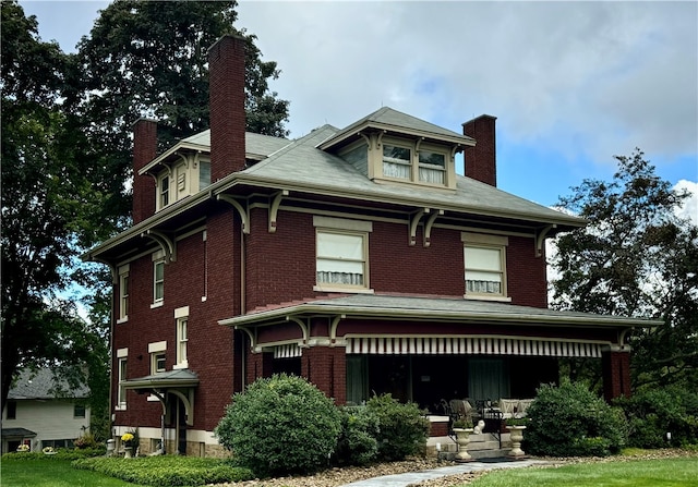 view of front of property featuring brick siding and a chimney