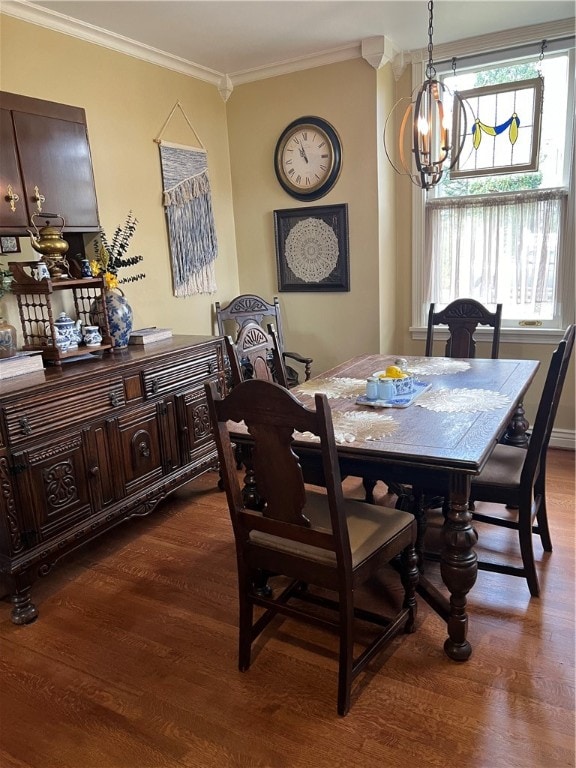 dining room featuring dark hardwood / wood-style flooring, ornamental molding, and a notable chandelier