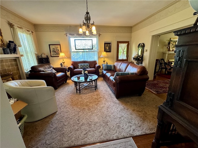 living room featuring a chandelier, wood-type flooring, a tile fireplace, and ornamental molding